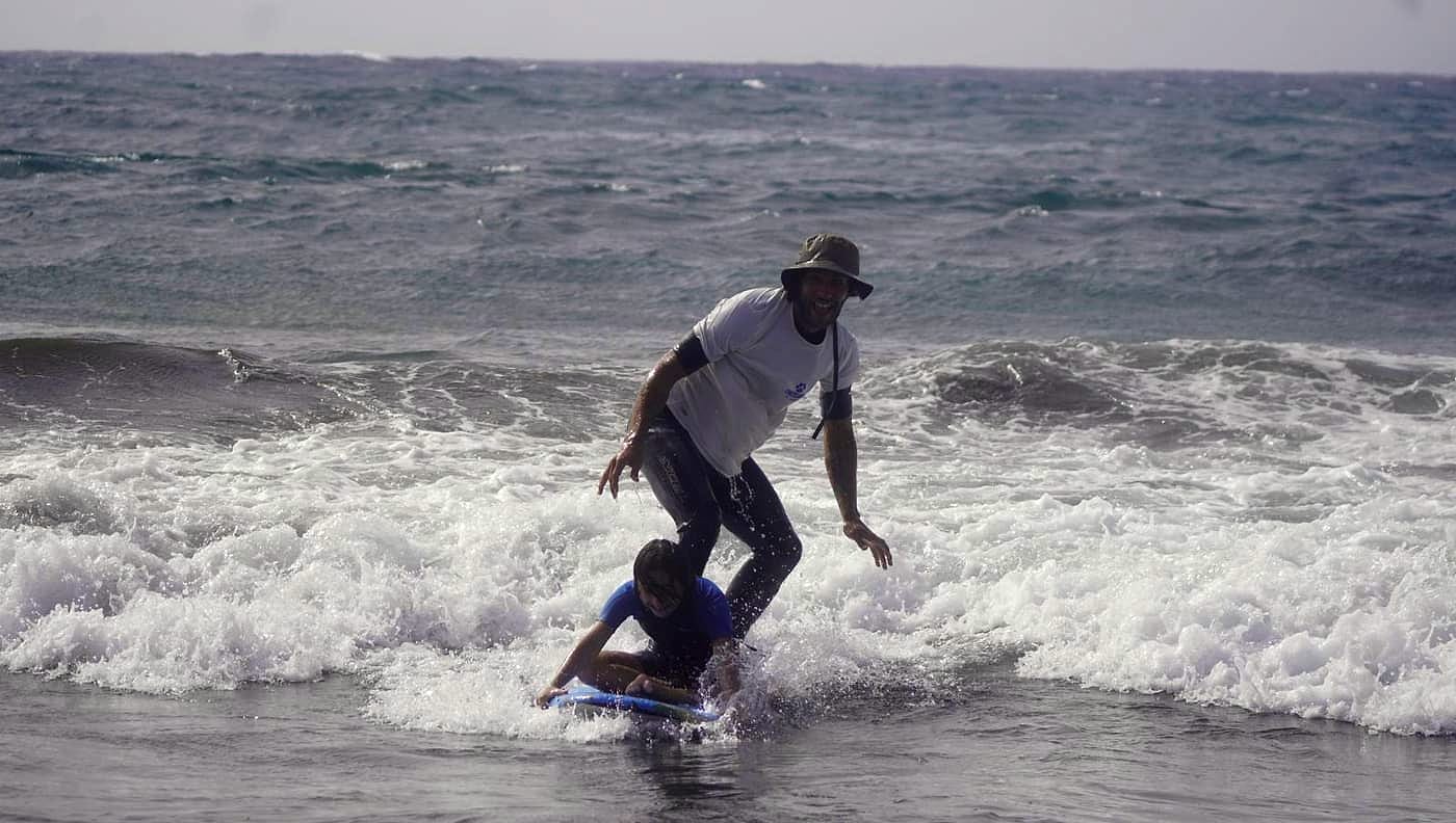 Ori Surf instructor accompanying an adaptive surfing student on a wave